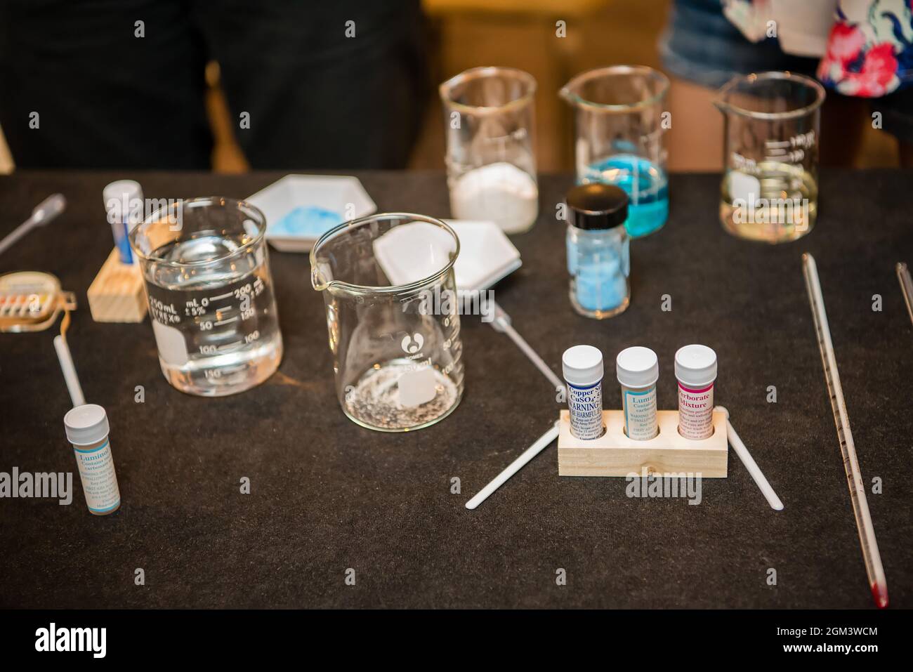 Science experiment materials including colorful liquid filled beakers