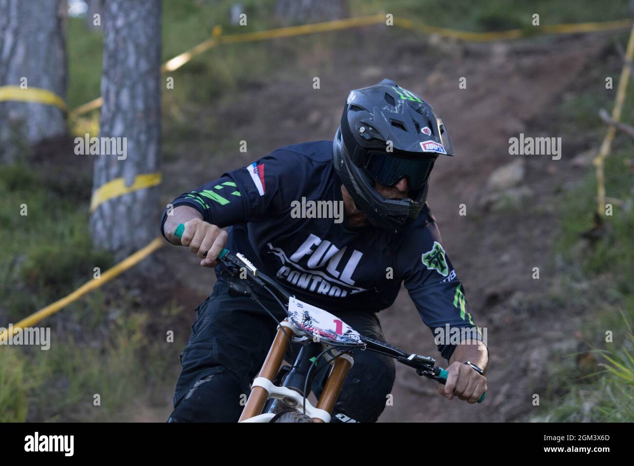 A closeup of a downhill mountain biker riding down a hill Stock Photo