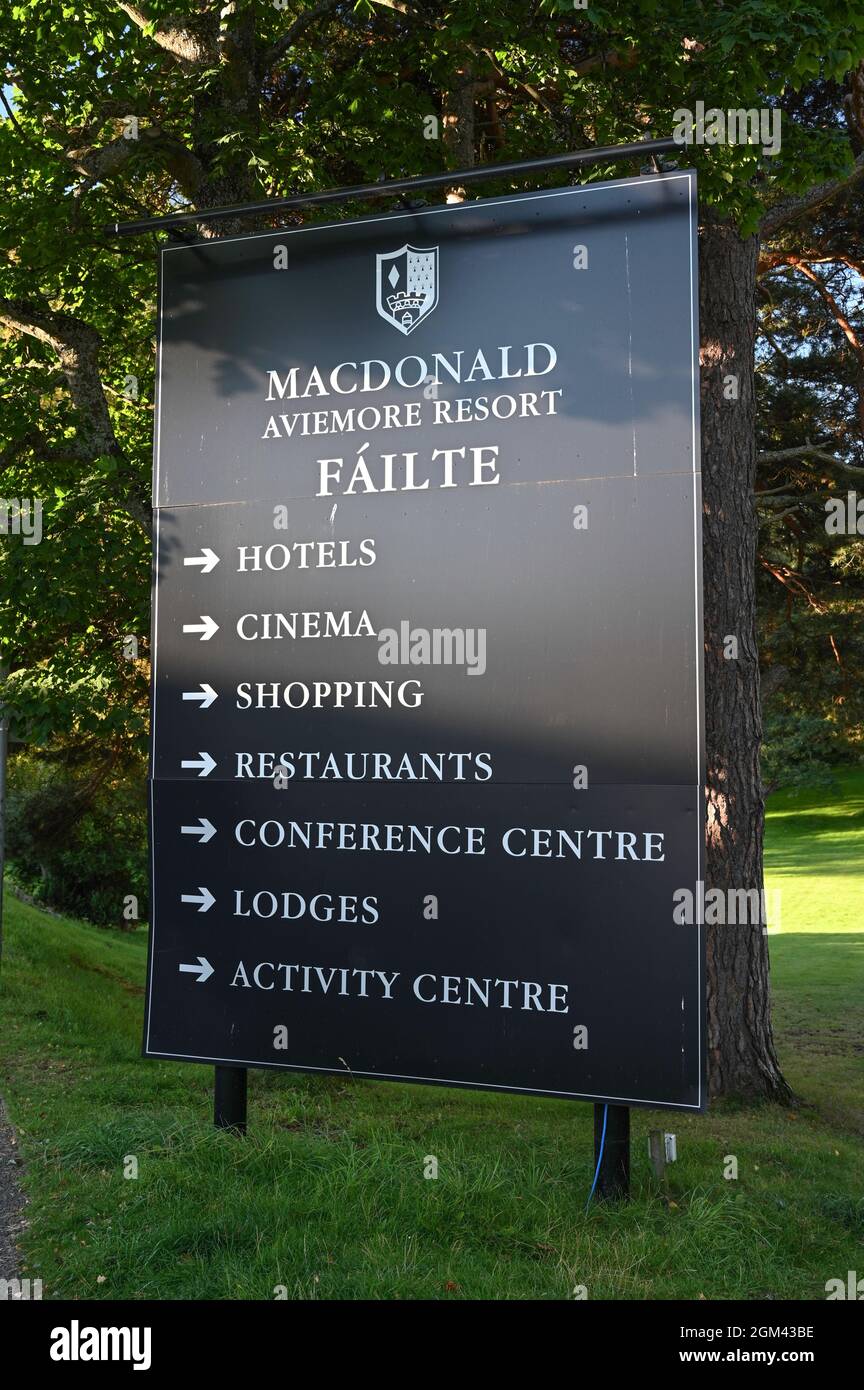 Sign for MacDonald Aviemore Resort with arrows pointing to facilities. Background of lawn and trees. Stock Photo