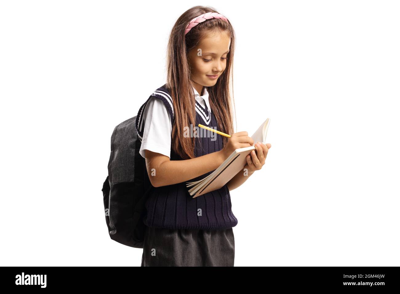 Schoolgirl standing and writing in a notebook isolated on white ...