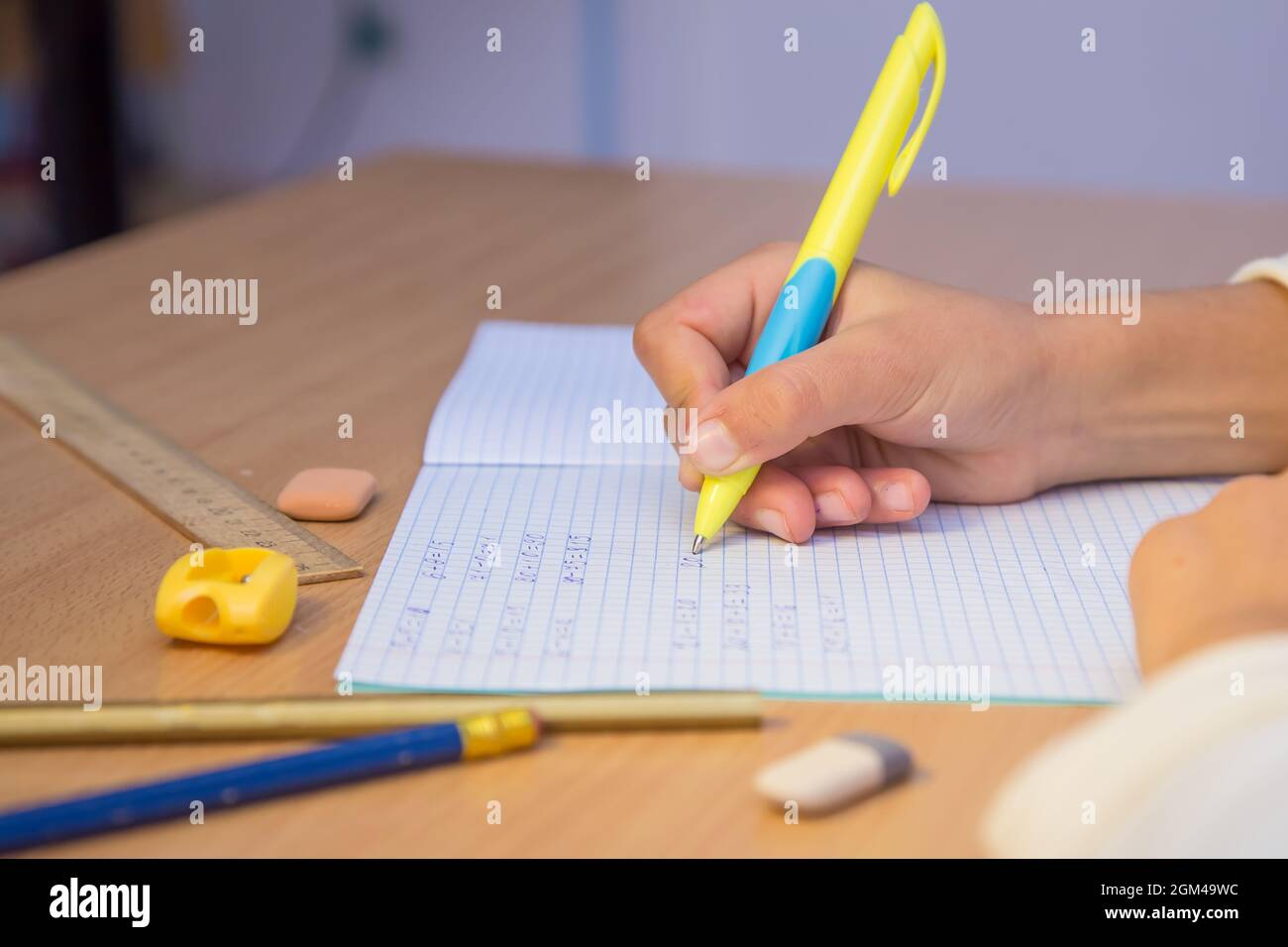 Pupils Notebook Pupil's hand writes with a ballpoint pen in a notebook close-up. A ...