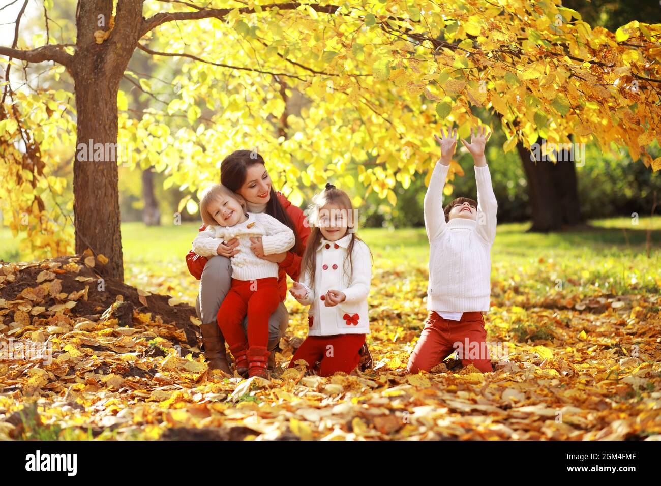 Young family on a walk in the autumn park on sunny day. Happiness to be ...