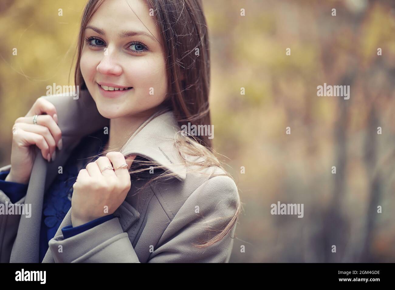 Young girl in a coat in autumn park Stock Photo - Alamy