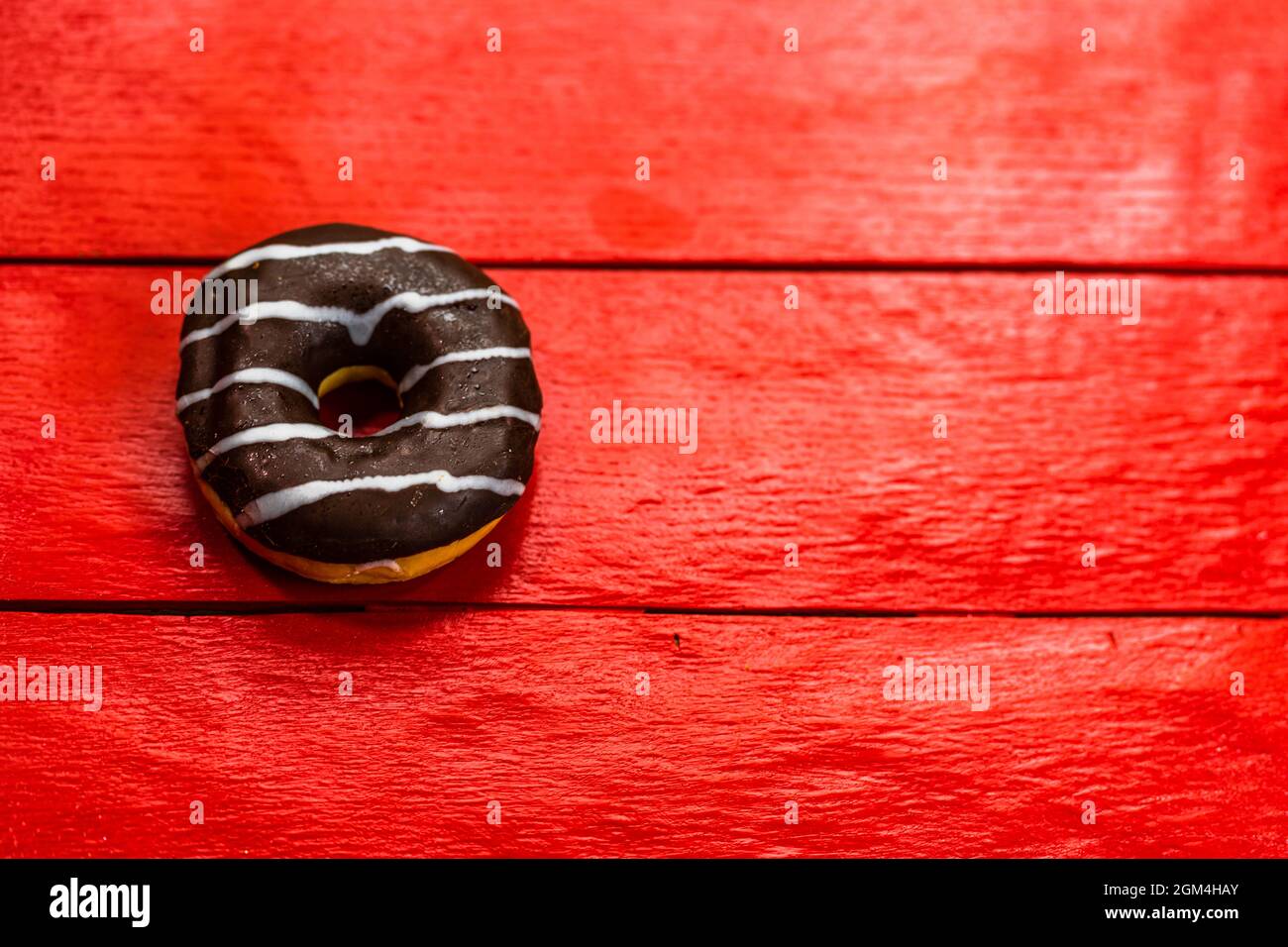 Top view of a chocolate donut on a red surface - copy space Stock Photo ...