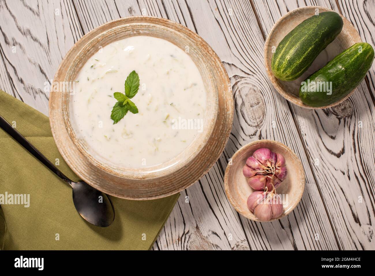 Greek tzatziki sauce on a gray background. Traditional Indian raita with cucumber, greek yogurt