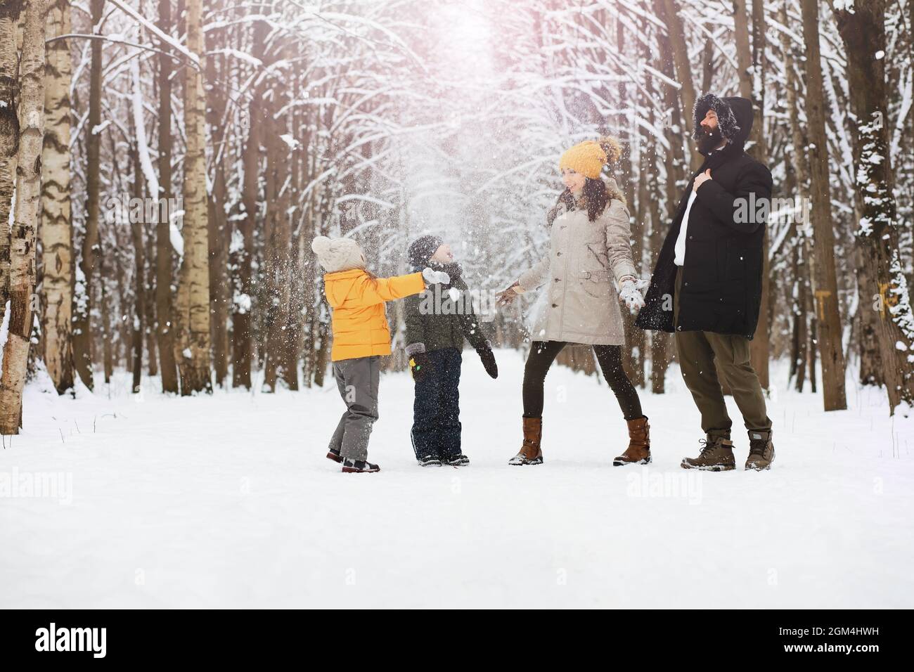 Happy family playing and laughing in winter outdoors in snow. City park ...