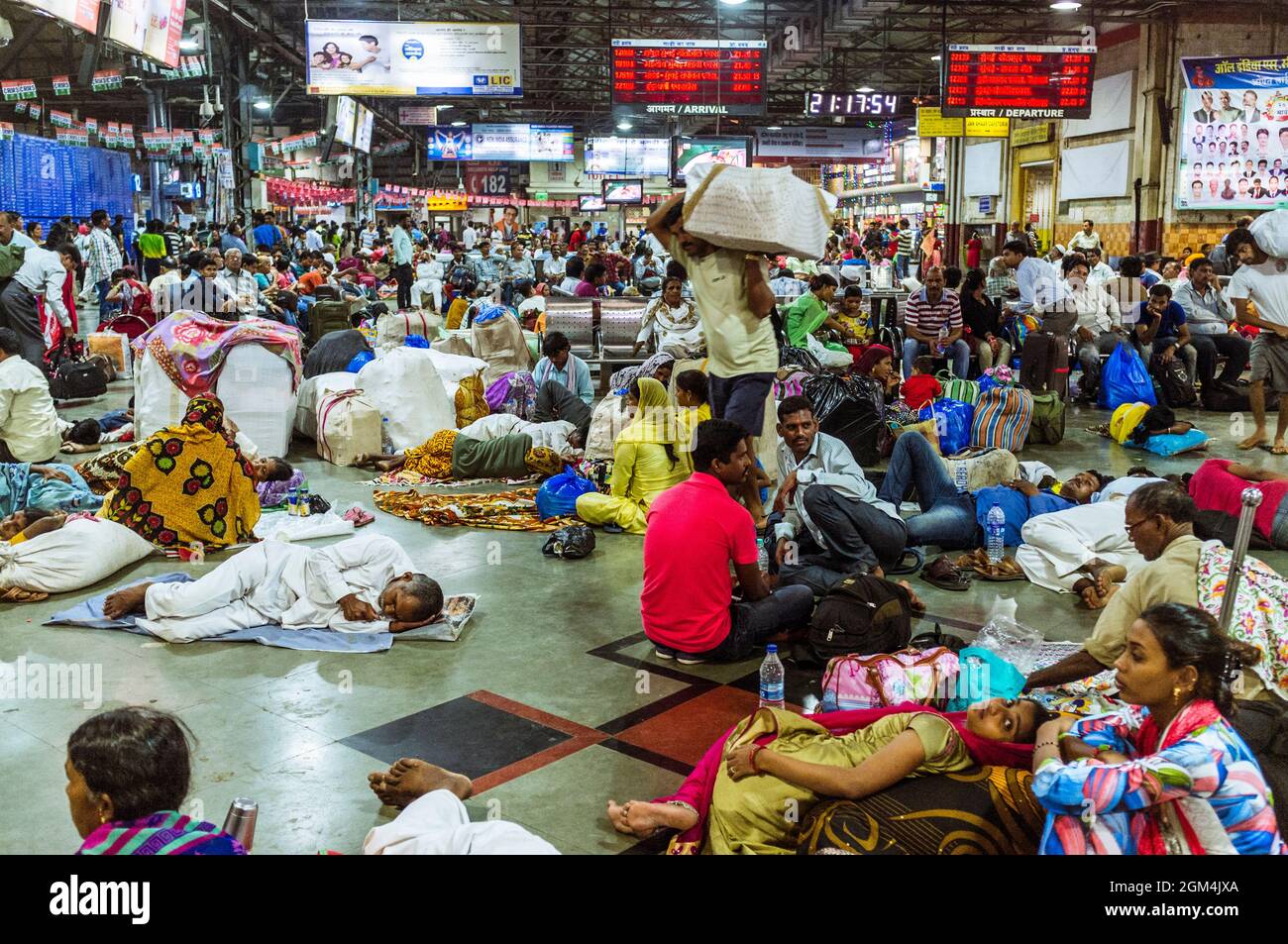 Mumbai, Maharashtra, India : Travellers wait for their trains inside the Chhatrapati Shivaji Terminus railway station (formerly Victoria Terminus) Stock Photo