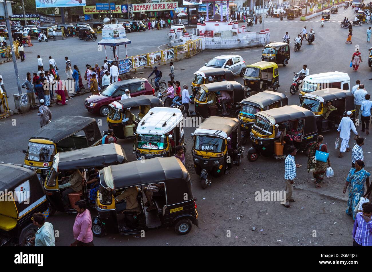 Bijapur, Karnataka, India : Auto rickshaws and passersby at Gandhi Chowk. Stock Photo