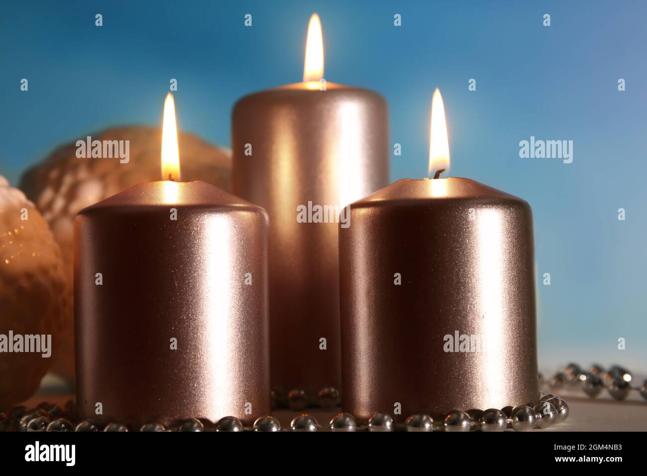 Metallic pillar candles burning on table, closeup Stock Photo Alamy