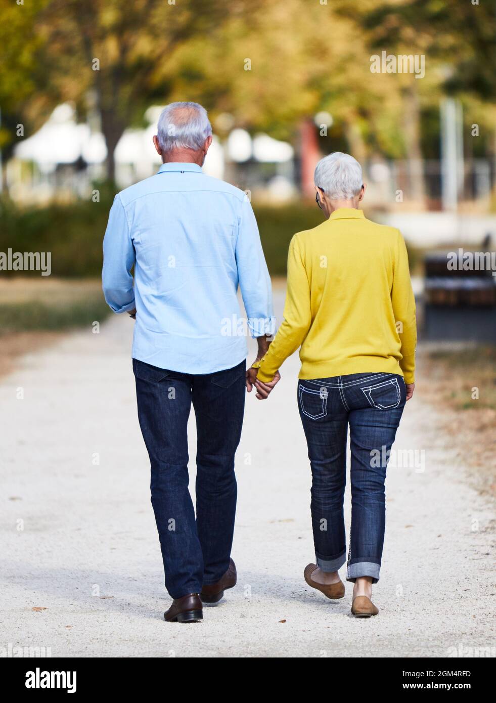 senior couple walking outdoors park talking love happy Stock Photo