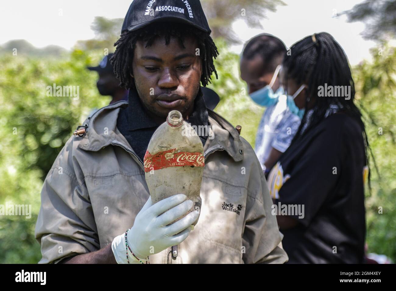 A member of Nakuru Waste Pickers Association looks for the barcode on a