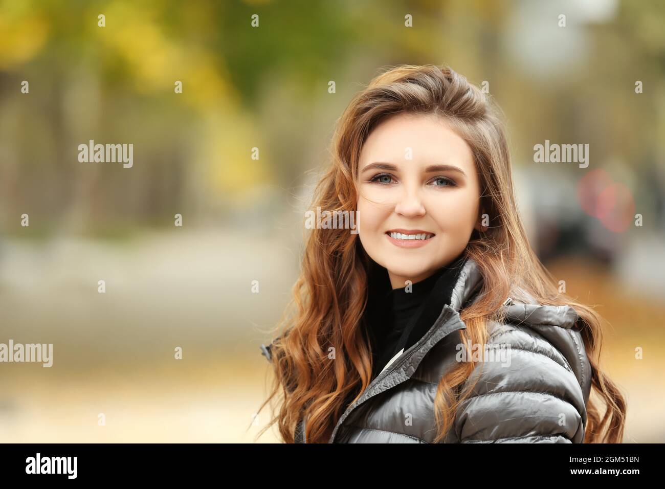 Beautiful smiling woman in puffer jacket outdoors Stock Photo - Alamy