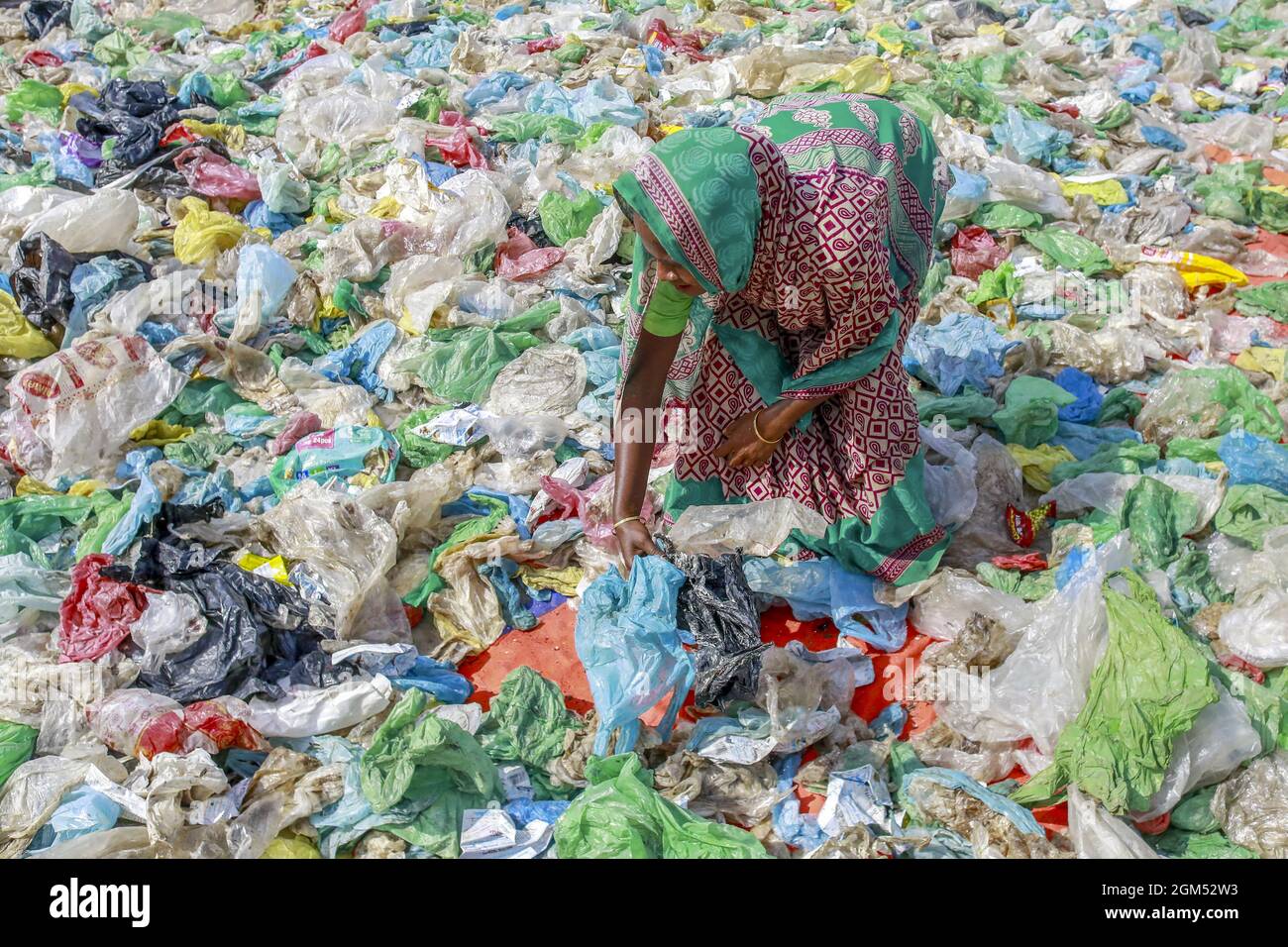 Dhaka, Bangladesh. 16th Sep, 2021. A woman sorts out plastic bags after