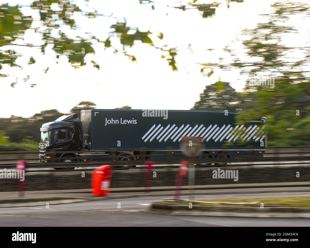 A panning shot of a John Lewis delivery truck drives along the M27 in Hampshire. As the shortage of truck drivers putting the strain on the delivery network of large businesses John Lewis Chairman Sharon White is putting in plans to make sure customers do not have their Christmas ruined by the lack of supplies. Stock Photo