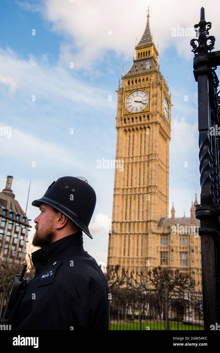 Juxtaposition with closeup of a guard and the Big Ben Clock tower in the background. Stock Photo