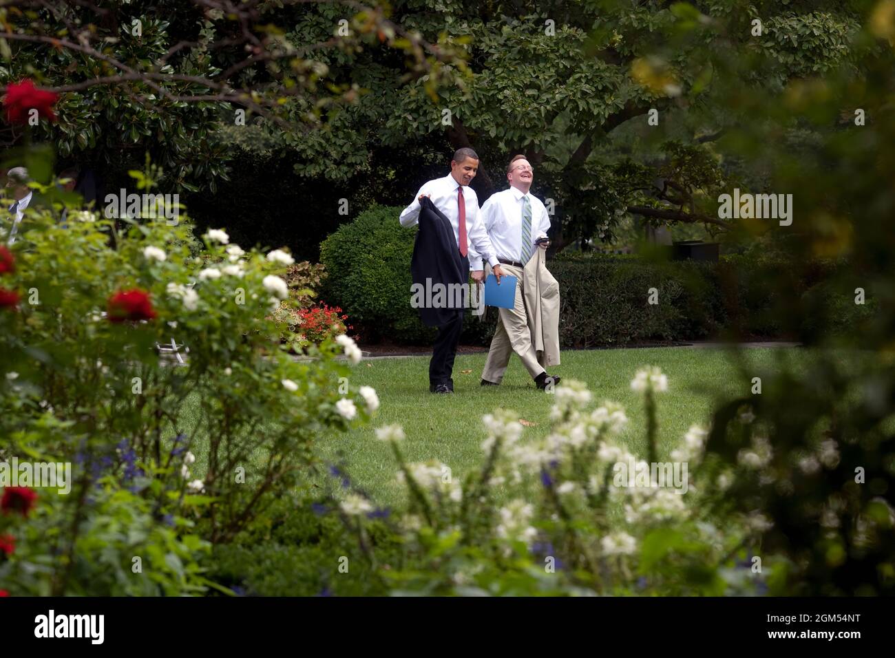 President Barack Obama and Press Secretary Robert Gibbs walk through the Rose Garden back to the Oval Office after the outdoor senior staff meeting on a pleasant summer day in Washington,  August 12, 2009.  (Official White House photo by Pete Souza) This official White House photograph is being made available only for publication by news organizations and/or for personal use printing by the subject(s) of the photograph. The photograph may not be manipulated in any way and may not be used in commercial or political materials, advertisements, emails, products, promotions that in any way suggests Stock Photo