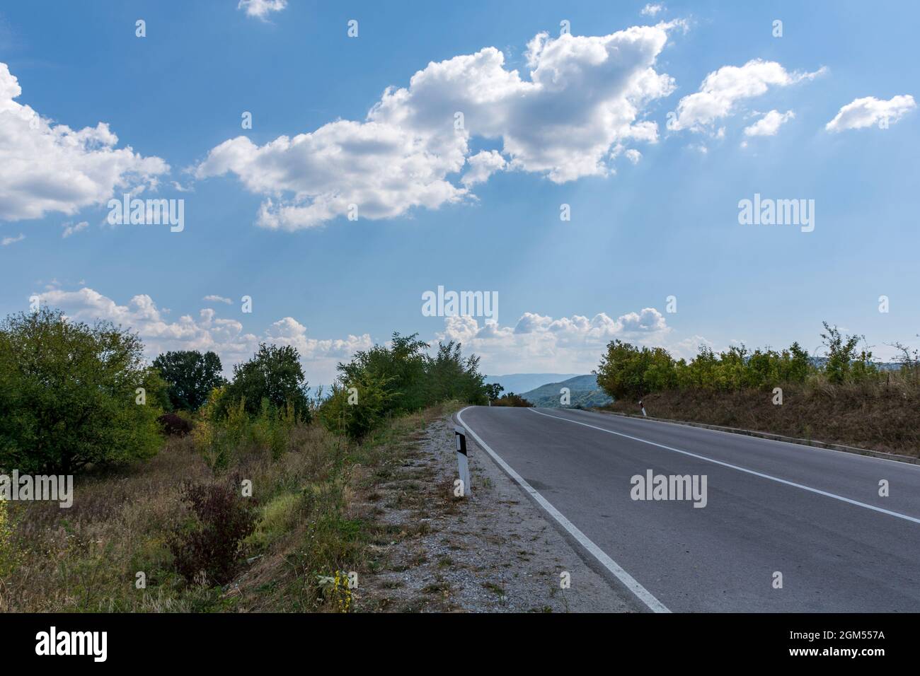 Asphalt empty road on a mountain on an autumn day and white clouds in the sky. Beautiful natural panoramic background concept Stock Photo