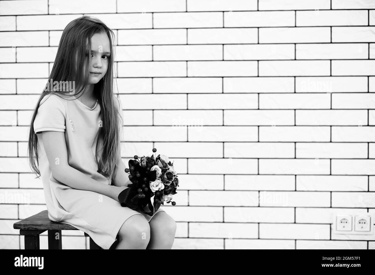 little girl is sitting on a chair and posing on the camera Stock Photo ...