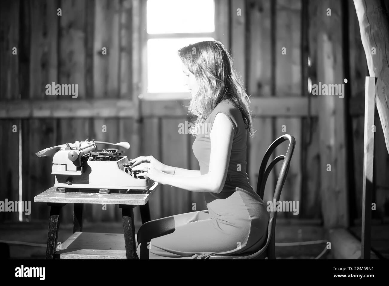 Silhouette of a beautiful girl in a dress on the background of a window ...