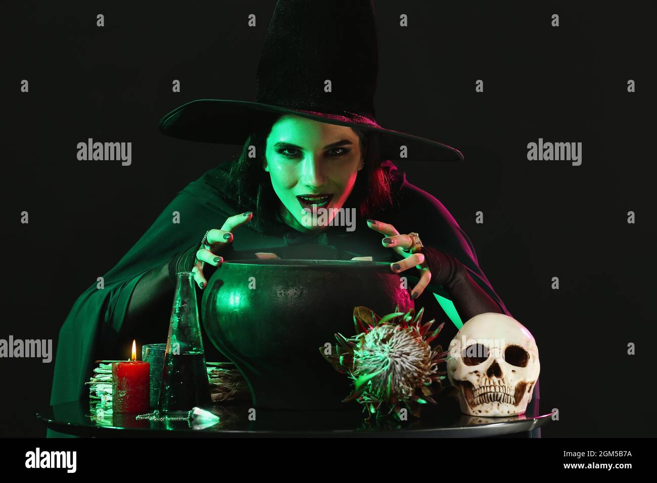 Witch performing ritual on black background Stock Photo - Alamy