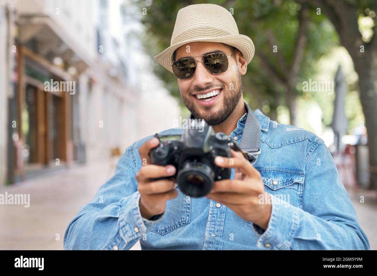 Handsome tourist checking photos in digital camera. High quality photo. Stock Photo