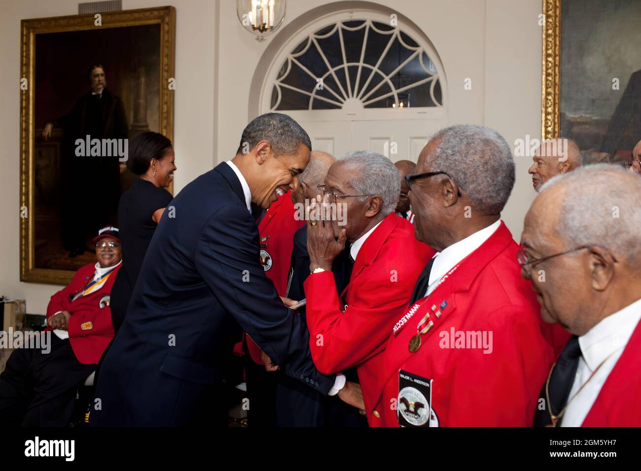 President Barack Obama and First Lady Michelle Obama greet Tuskeegee Airmen in the East Garden Room of the White House prior to a screening of the film, “Red Tails” in the Family Theater, Jan. 13, 2012. (Official White House Photo by Pete Souza) This official White House photograph is being made available only for publication by news organizations and/or for personal use printing by the subject(s) of the photograph. The photograph may not be manipulated in any way and may not be used in commercial or political materials, advertisements, emails, products, promotions that in any way suggests app Stock Photo