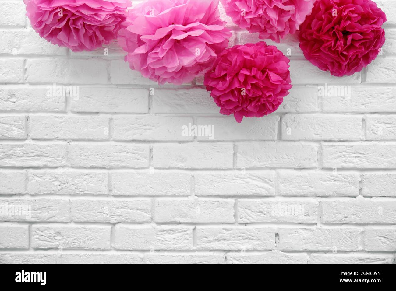 Artificial flowers for baby shower party on white brick wall Stock
