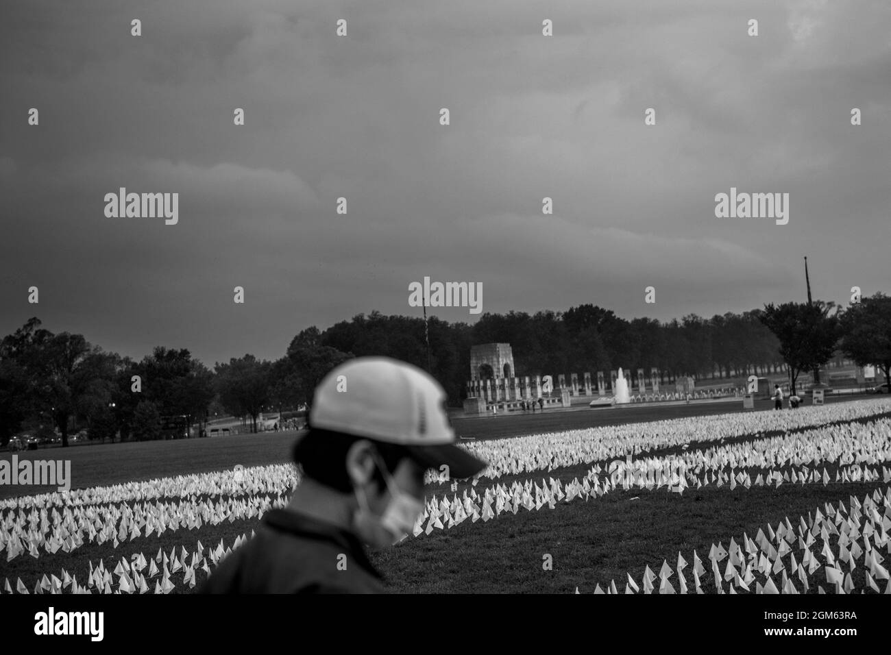 A man works at installing some of the 660,000 white flags, representing the number of US lives lost to Covid-19, on the National Mall in Washington, DC, Thursday, September 16, 2021. The project, by artist Suzanne Brennan Firstenberg, titled âIn America: Rememberâ, will be on display September 17, 2021 through October 3, 2021. Credit: Rod Lamkey/CNP Stock Photo