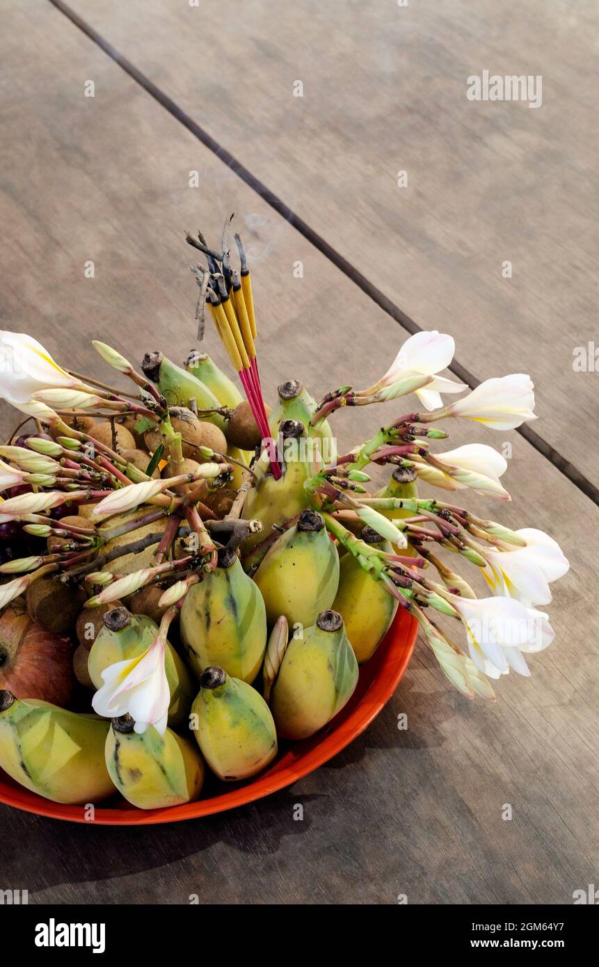 buddhist offering bowl with incense fruit and flowers detail in thailand Stock Photo