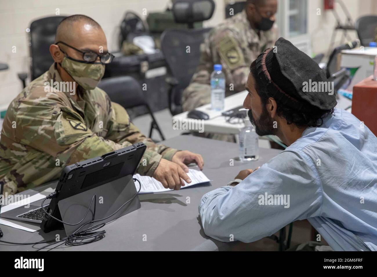 U.S. Army Staff Sgt. Valente Real, a human resource specialist with the 155th Combat Sustainment Support Battalion, in-processes an Afghan evacuee at Camp As Sayliyah, Qatar, August 26, 2021. Soldiers continue to support Department of Defense and Department of State teammates in Afghanistan evacuation efforts with care and compassion at various U.S. Central Command locations. (U.S. Army photo by Spc. Elizabeth Hackbarth, U.S. Army Central Public Affairs) Stock Photo