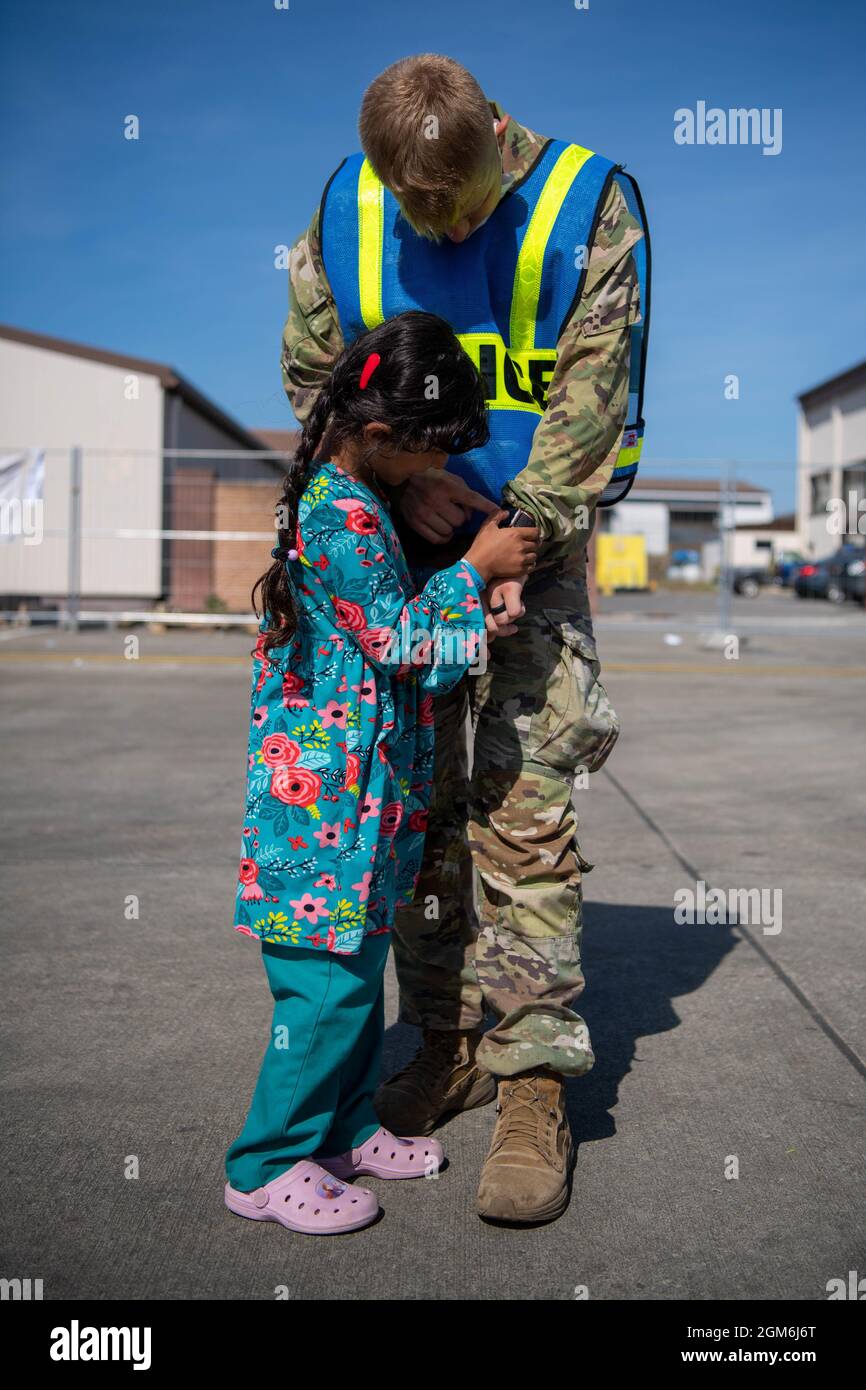 U.S. Army Pfc. Brandon Mercer, Infantry Grenadier 1/2 Cavalry Regiment, and a little girl play at Ramstein Air Base, Germany, Sept. 8, 2021. Operation Allies Refuge has been the largest humanitarian evacuation airlift in U.S. history. (U.S. Air Force photo by Airman 1st Class Alexcia Givens) Stock Photo