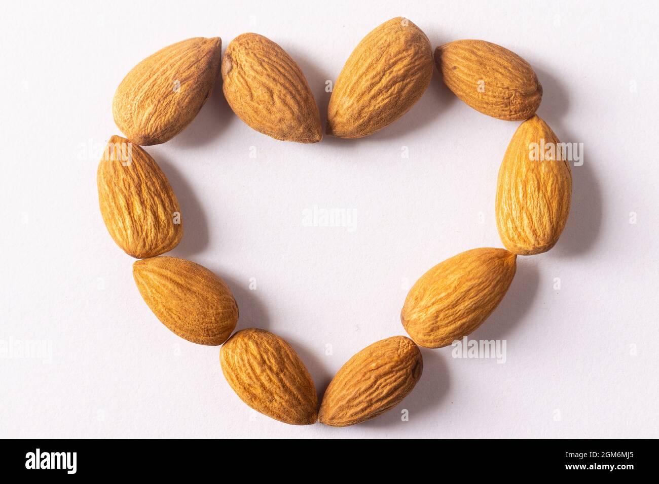 Almonds arranged in heart shape on white background Stock Photo Alamy