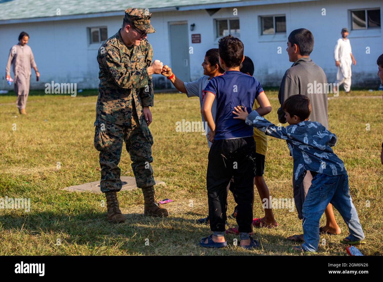 U.S. Navy Petty Officer 3rd Class Theodore Marcus, a Religious Program Specialist with the 26th Marine Expeditionary Unit (MEU), interacts with Afghan children during Operation Allies Welcome in Fort Pickett, Virginia, Sept. 15, 2021. The MEU command element and other supporting units from 3rd Battalion, 6th Marine Regiment, 2d Marine Division are providing support to Operation Allies Welcome. The Department of Defense, through U.S. Northern Command, and in support of the Department of Homeland Security, is providing transportation, temporary housing, medical screening, and general support for Stock Photo