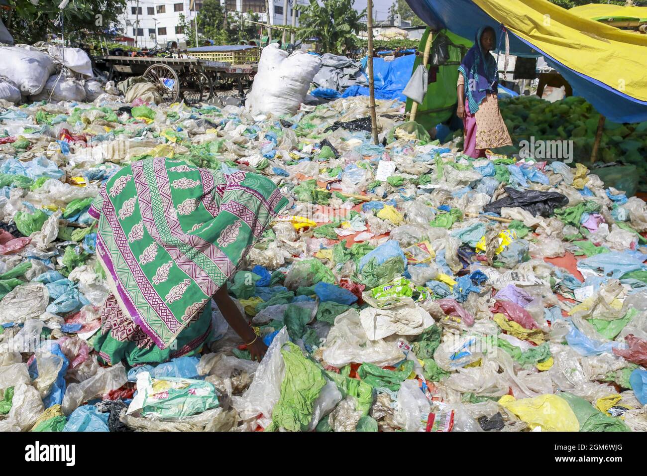 A woman sorts out plastic bags after they are collected from roadsides