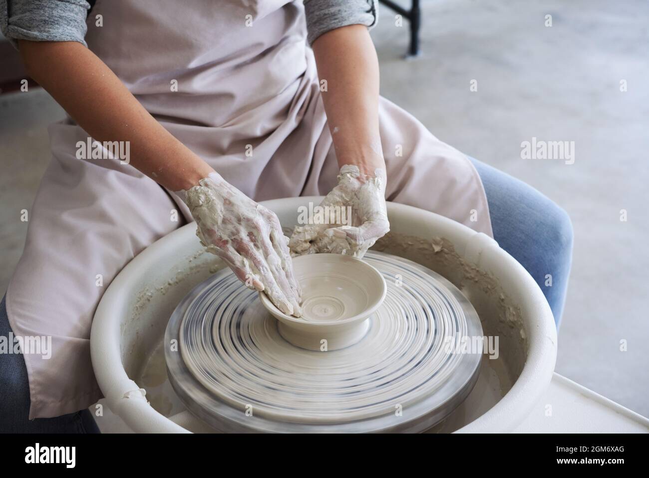 Master class in pottery workshop, woman making dish out of white clay Stock Photo