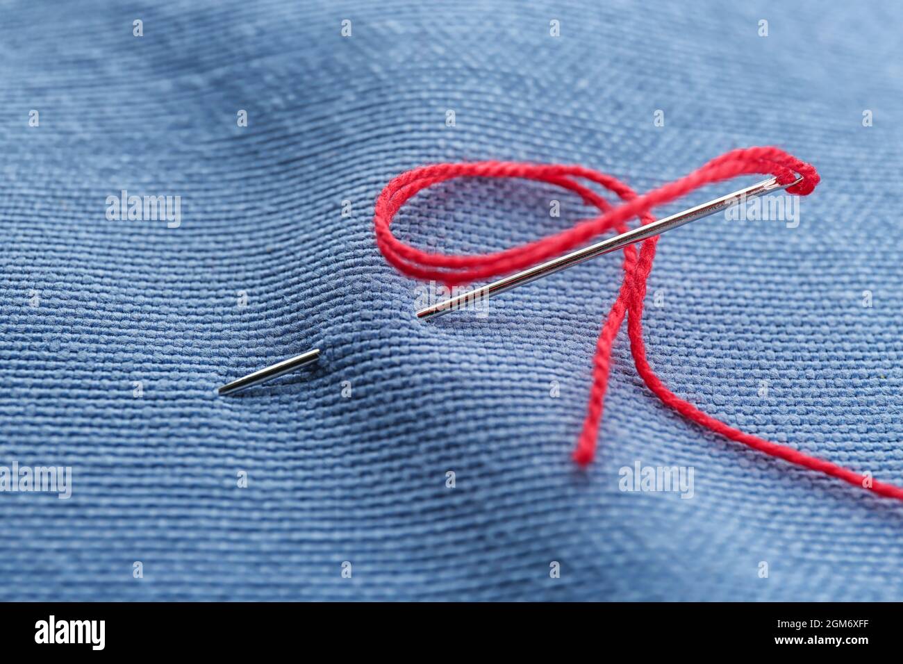 Fabric with sewing thread and needle, closeup Stock Photo Alamy