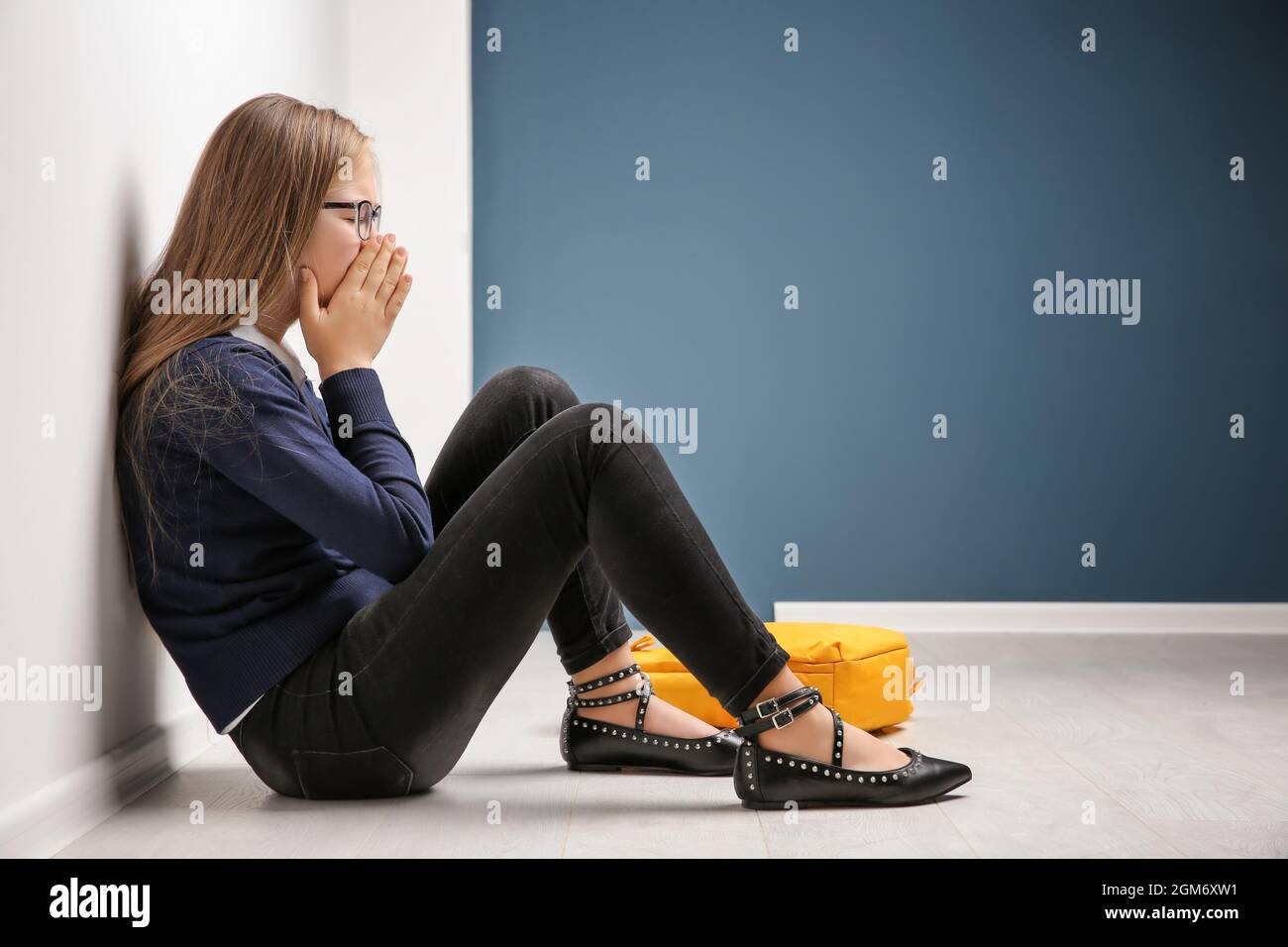 Upset teenage girl sitting on floor indoors Stock Photo - Alamy