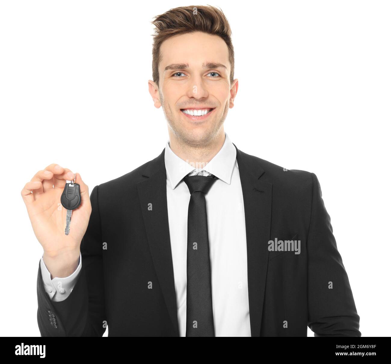 Young salesman holding car key on white background Stock Photo - Alamy