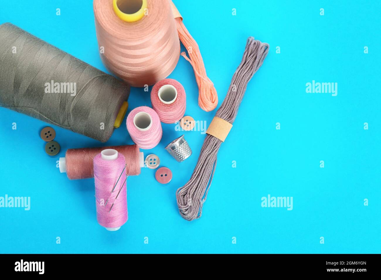 Sewing accessories and threads on color background Stock Photo - Alamy