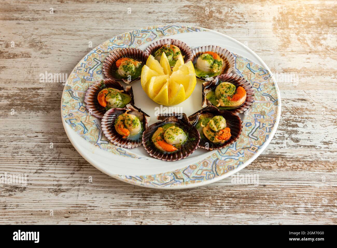 Plate of impressive scallops in green sauce cooked in a Galician restaurant in northwestern spain Stock Photo