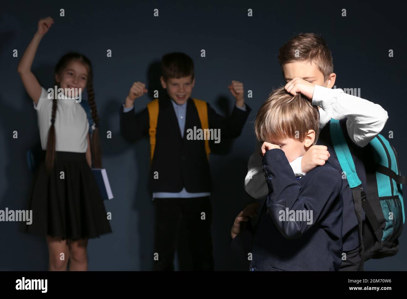 Little boy bullying his classmate on dark background Stock Photo - Alamy
