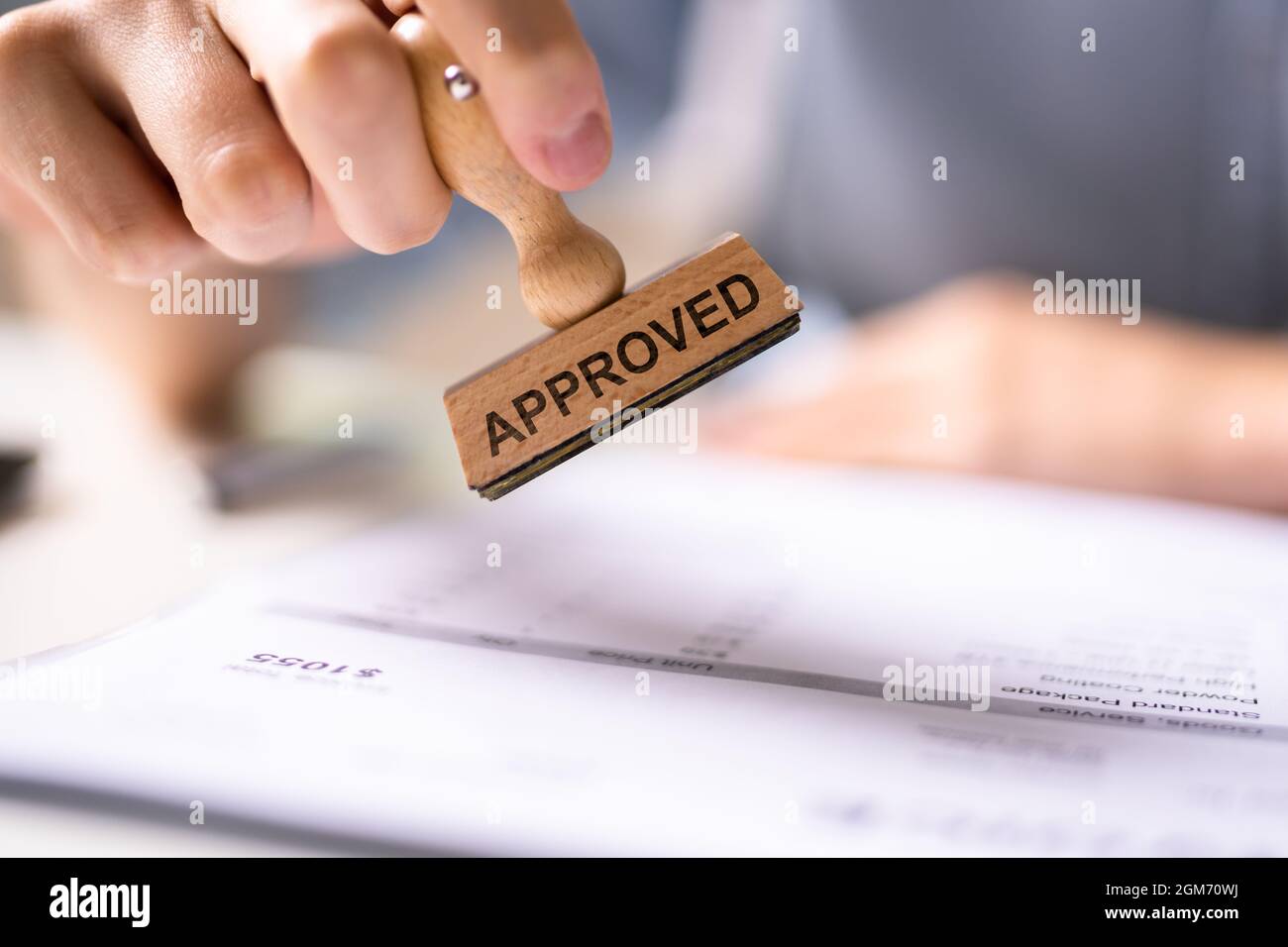 Hand Stamping With Approved Stamp On Document At Desk Stock Photo - Alamy