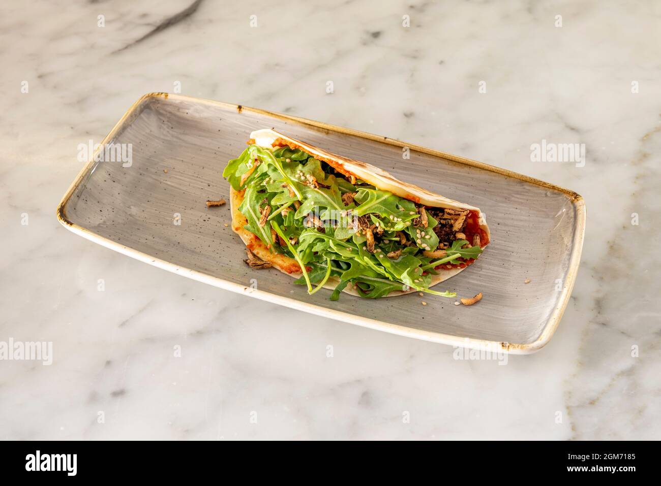 Vegan taco with wheat tortilla, tomato, sesame seeds, arugula and rice