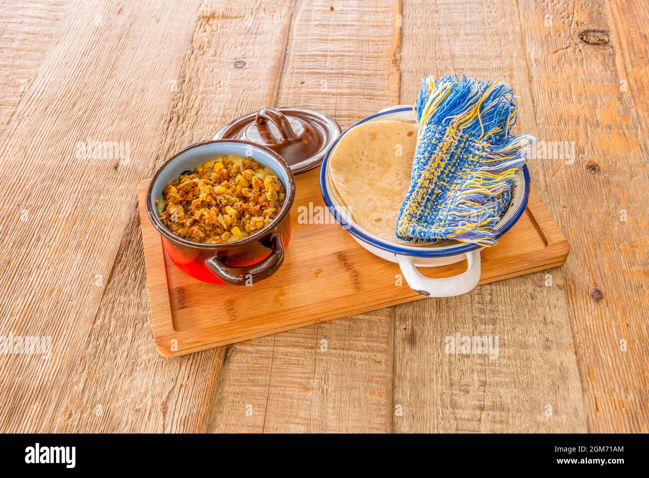 Enamel tart pan with Mexican flower cheese tacos with corn tortillas in a white bowl Stock Photo