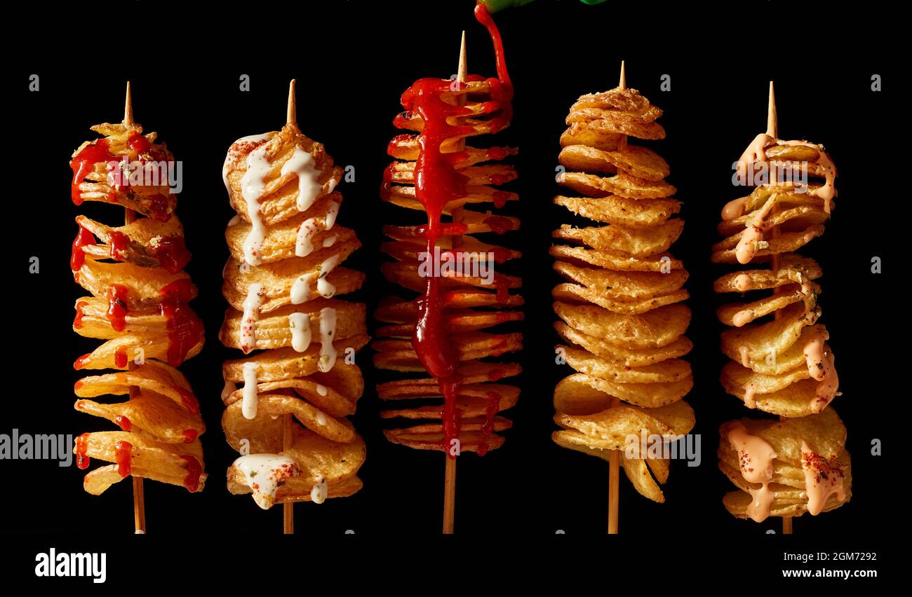 Top view layout of yummy crispy deep fried tornado potatoes on skewers