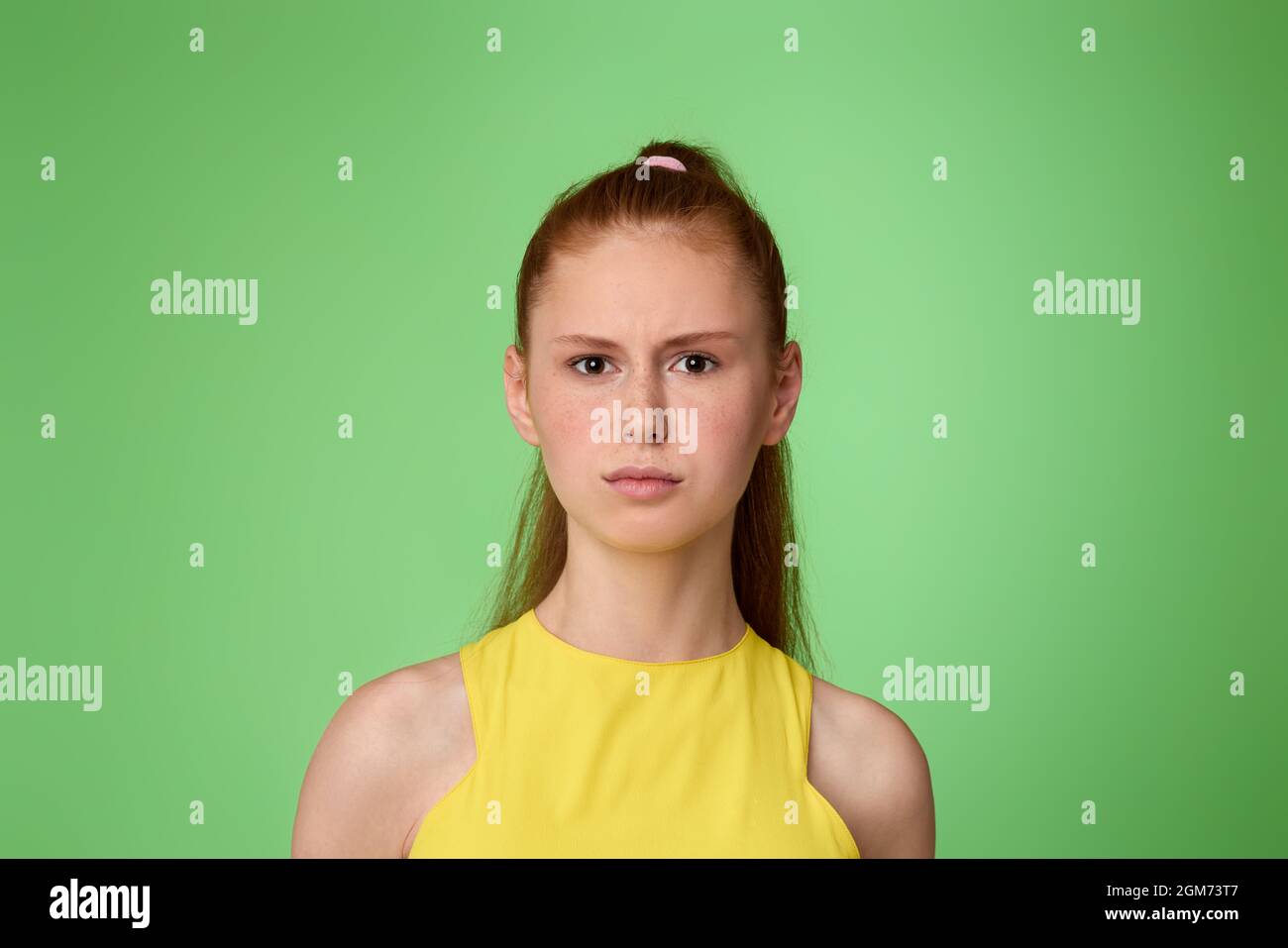 sad teen girl on green background. Human emotions Stock Photo