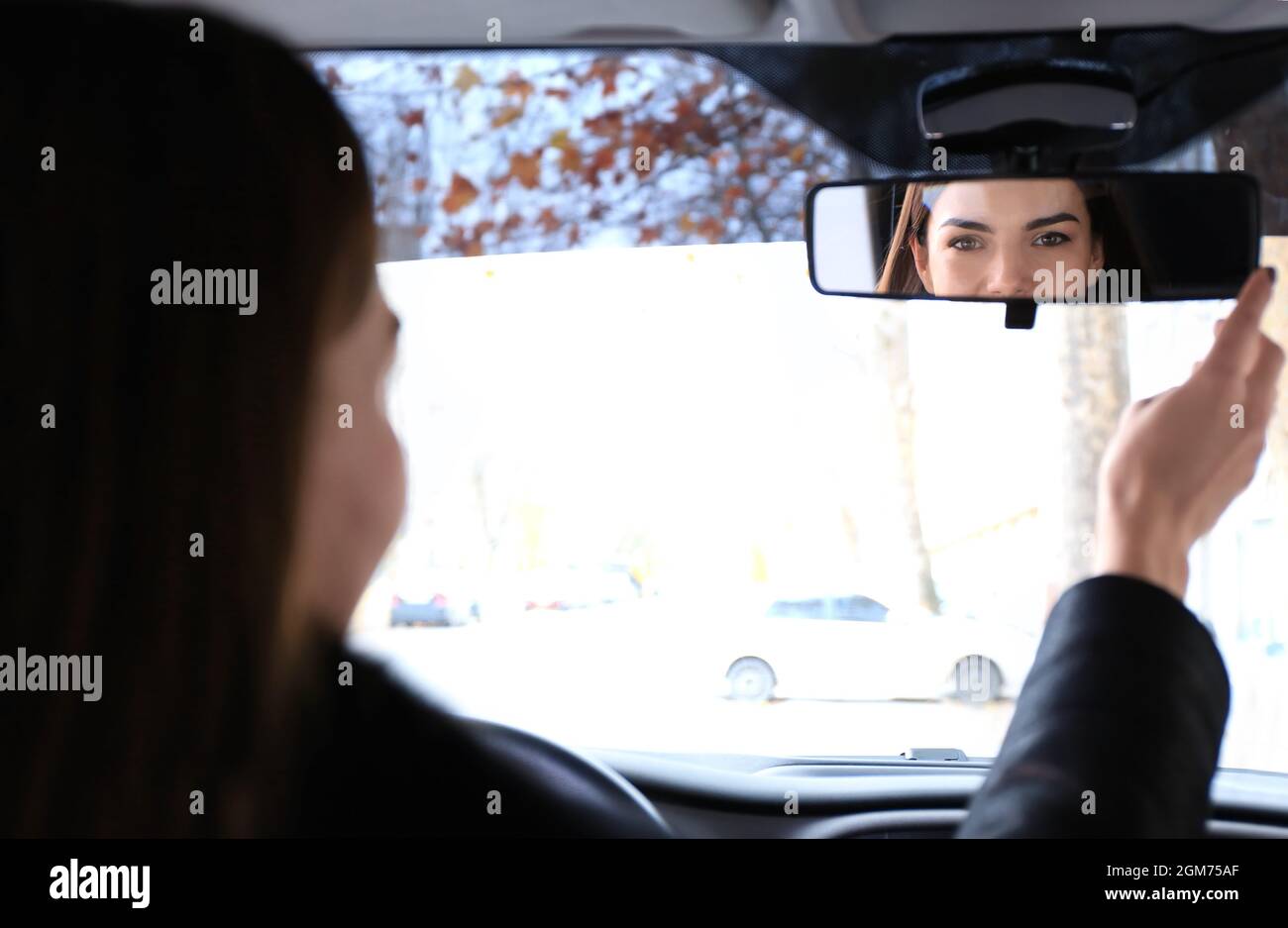 Woman adjusting rear view mirror in car Stock Photo Alamy