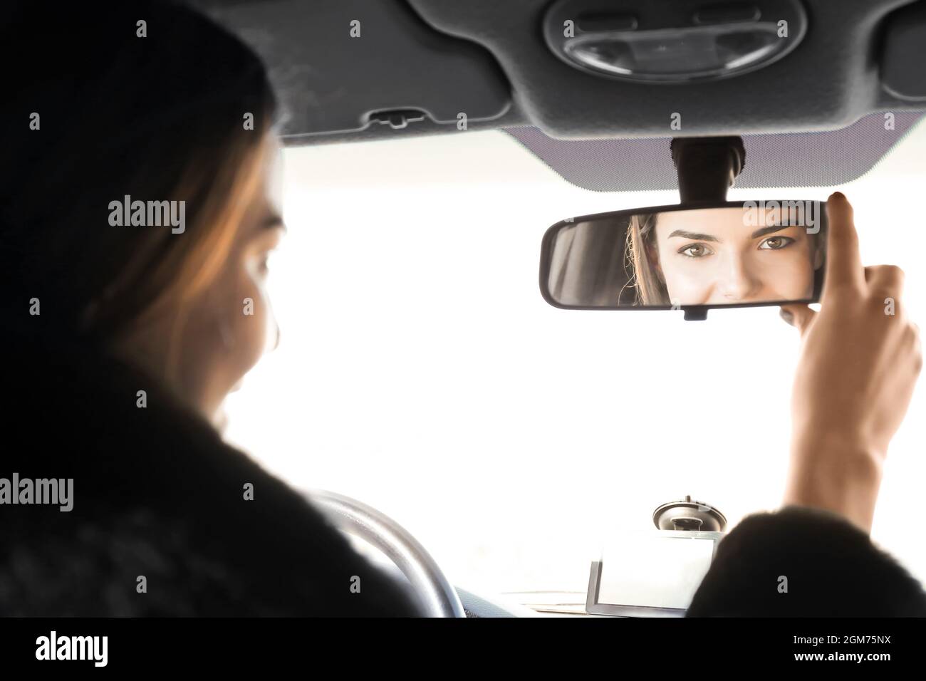 Woman adjusting rear view mirror in car Stock Photo Alamy