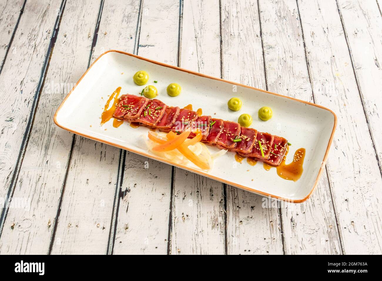 Red tuna tataki recipe with soy sauce, vegetable filigree and hints of chives and seeds Stock Photo