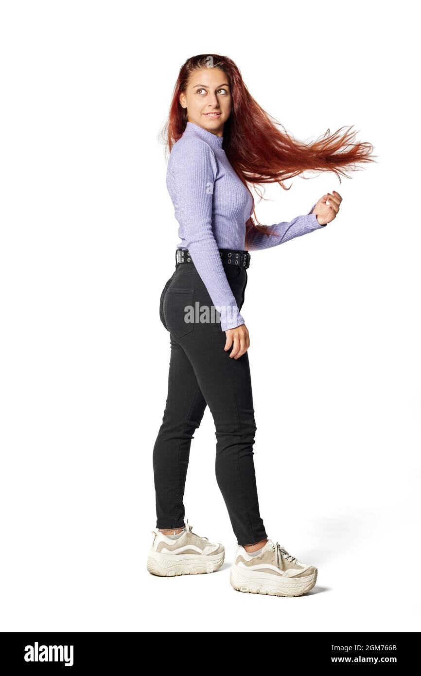 young Caucasian woman plays with the hair that is floating on an isolated white background in studio Stock Photo